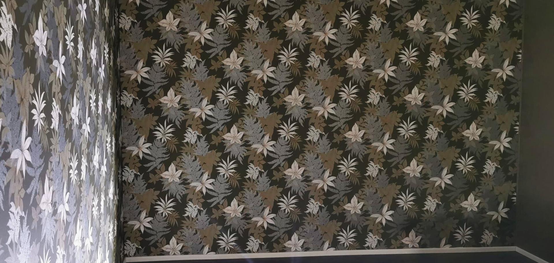 Starttimaalaus Oy:n yritt&auml;j&auml; Nooran tekem&auml; tapettiasennus kukkatapetilla