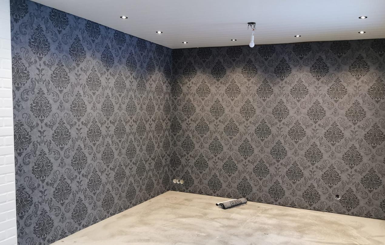 Starttimaalaus Oy:n yritt&auml;j&auml; Nooran asentama tyylik&auml;s harmaa kuvioitu tapetti huoneen sein&auml;ll&auml;