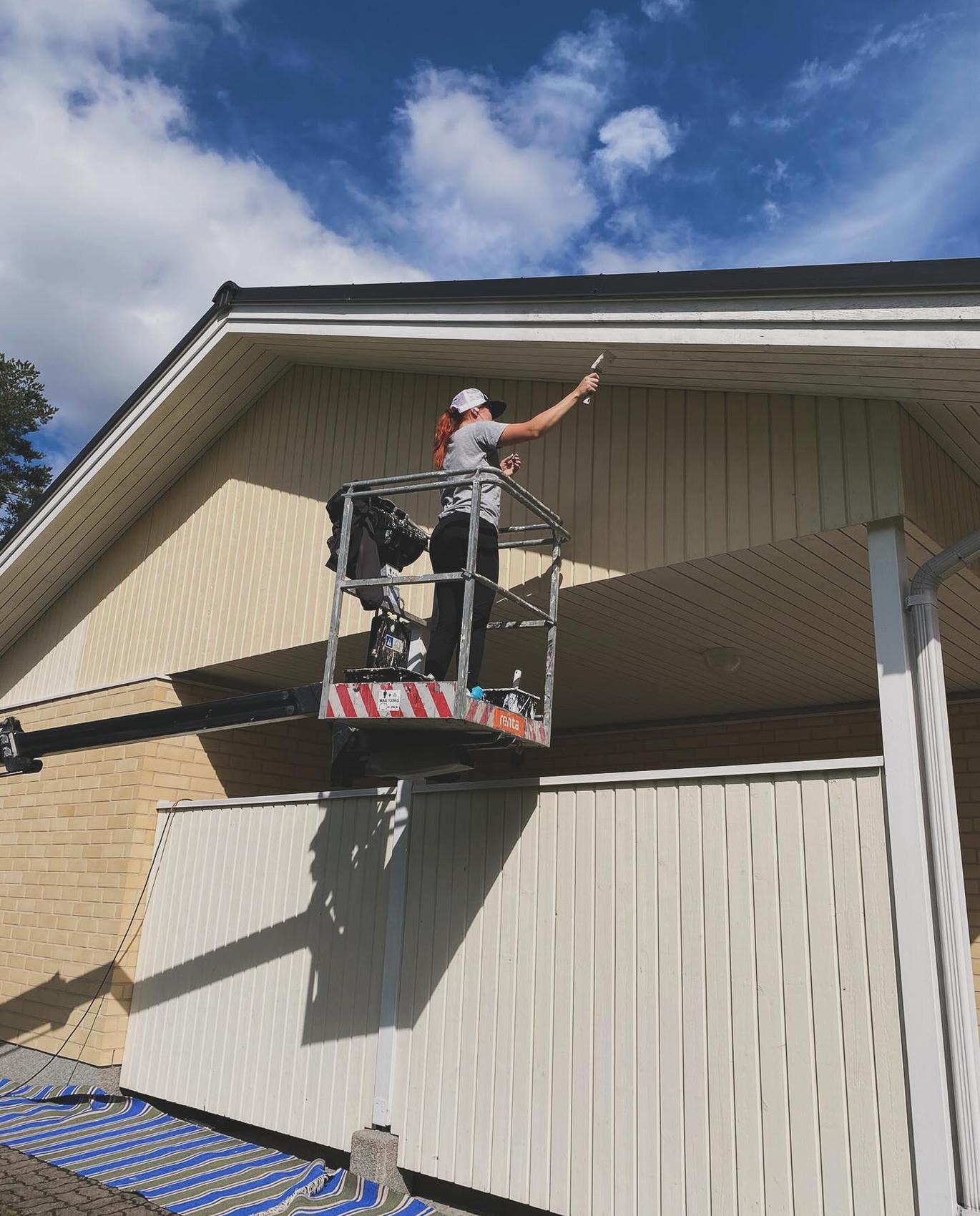 Starttimaalaus Oy:n yrittäjä Noora tekemässä talon ulkomaalausta.