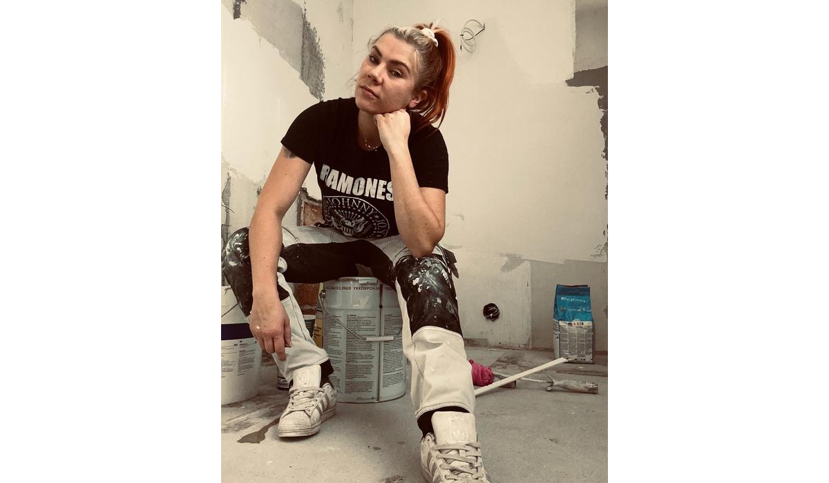 StarttiMaalaus Oy:n yritt&auml;j&auml; Noora H&auml;m&auml;l&auml;nen istumassa suuren maalipurkin p&auml;&auml;ll&auml;.